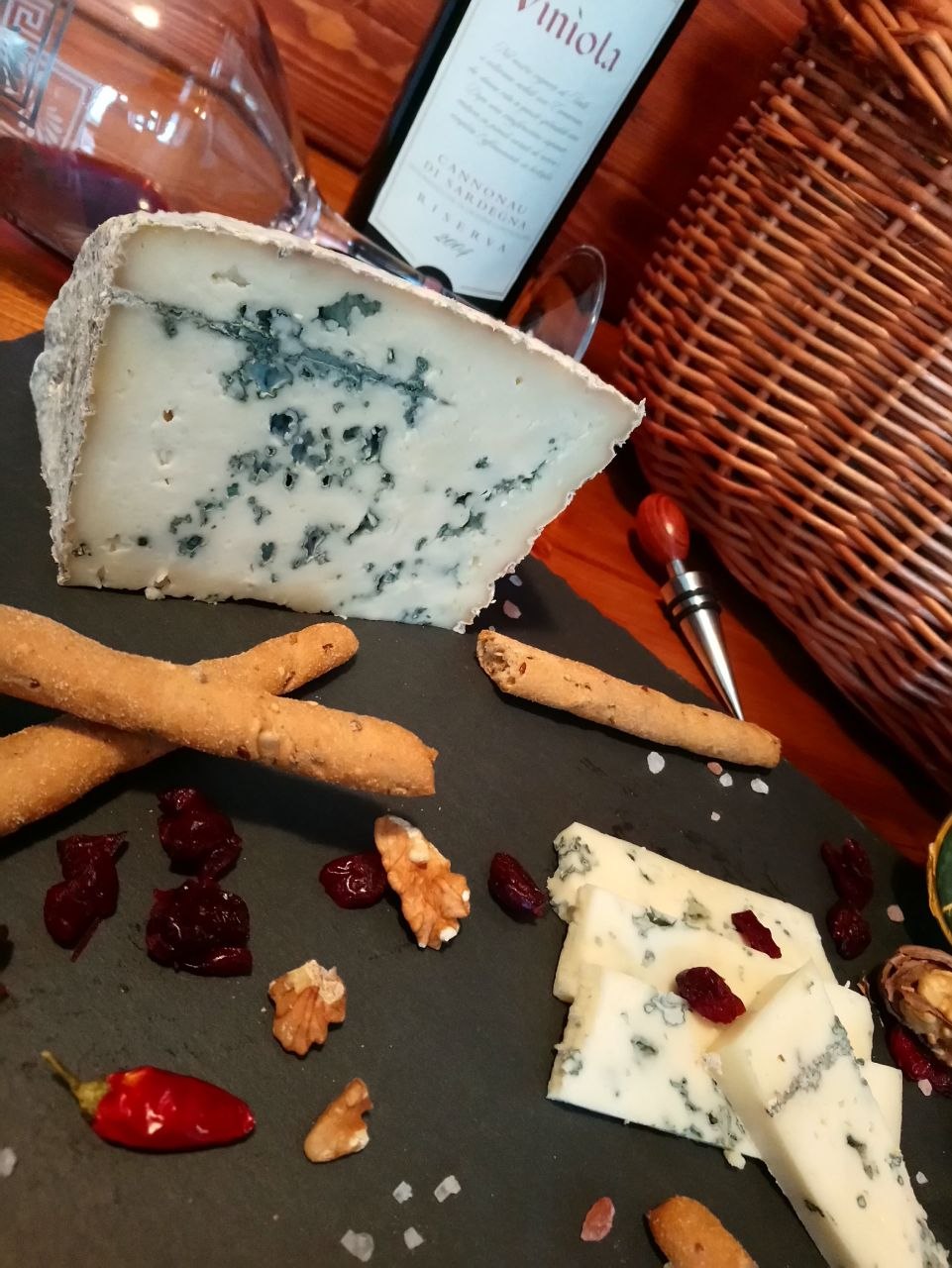 A wedge of Ovinsard on slate with Cannonau wine and grissini